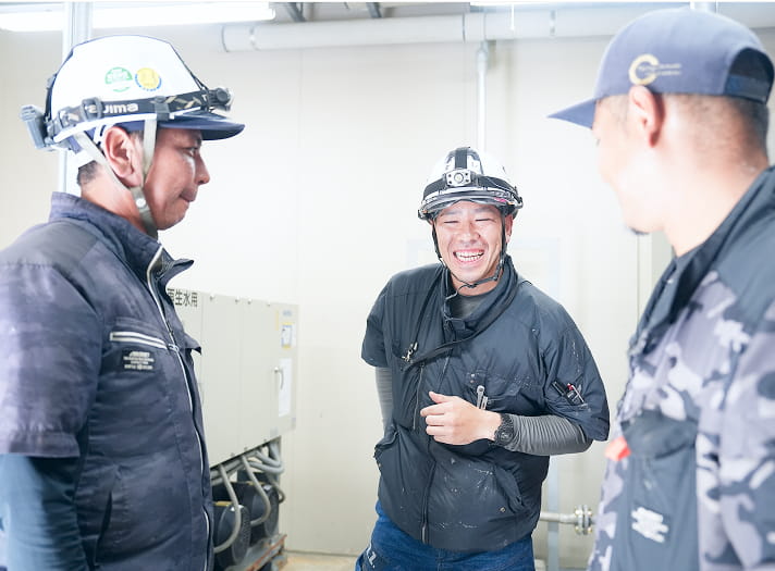 ヘルメットを着用して会話する作業員たち