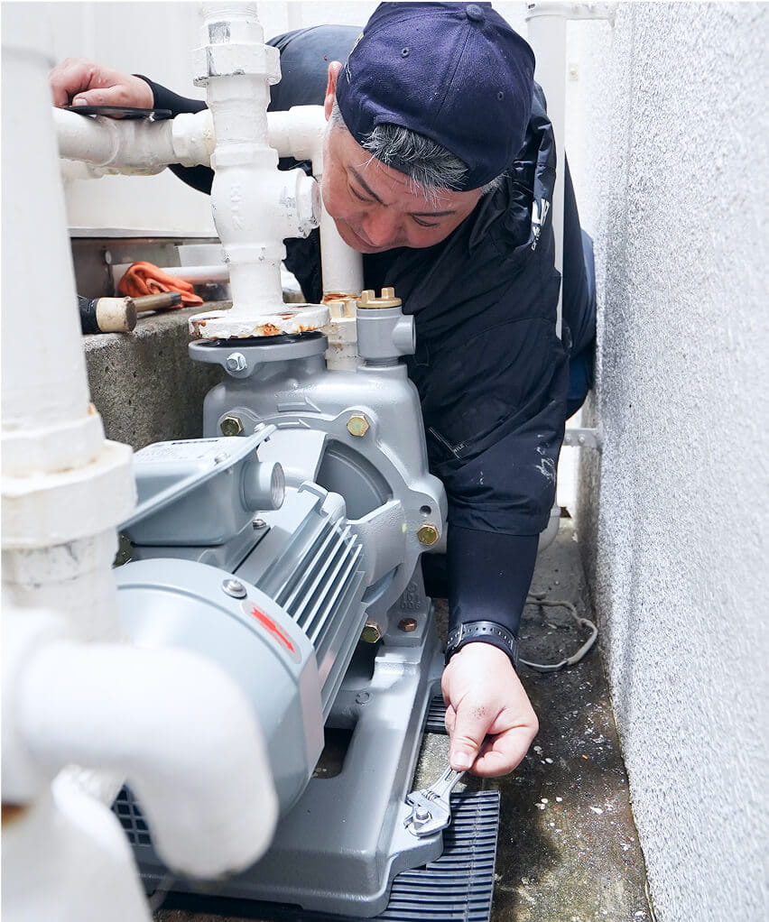 工具で機械を調整している作業員