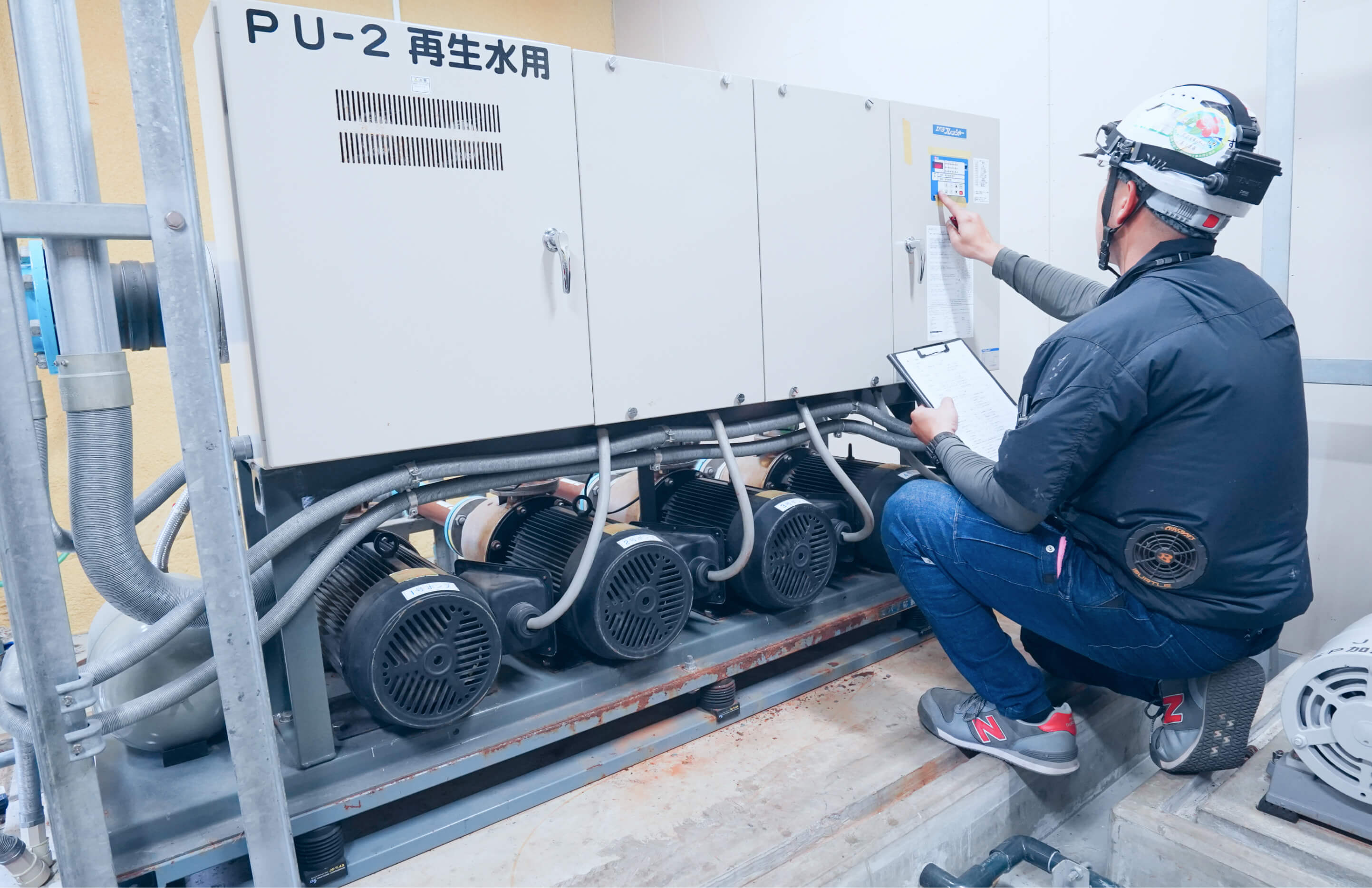 作業員が制御盤の点検を行っている様子